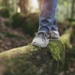 Woman walking on a log in the forest