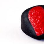 Black stone with a painted red heart isolated on white background