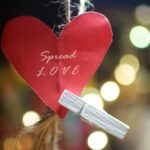 Spread Love. Positive words on red heart paper shape.