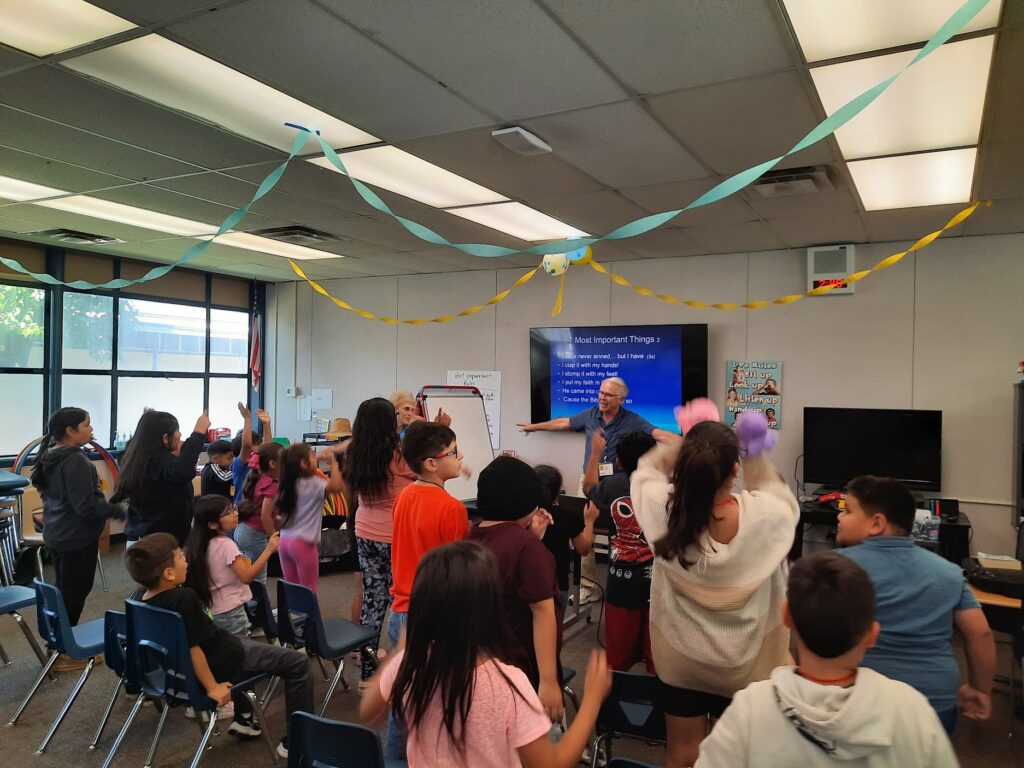 Two adults teach a group of students