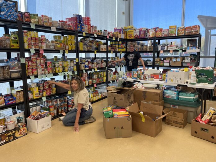 A woman stocks shelves with food.