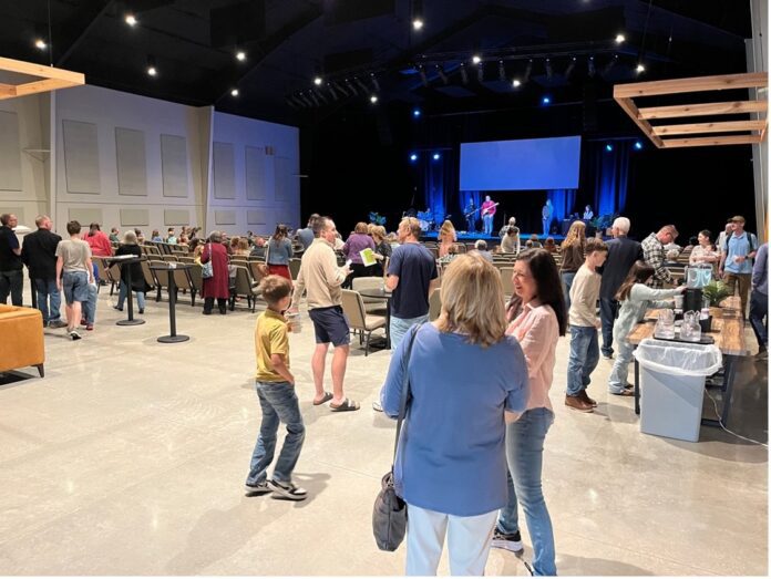 Cross Timbers new worship center People visit in a church sanctuary.