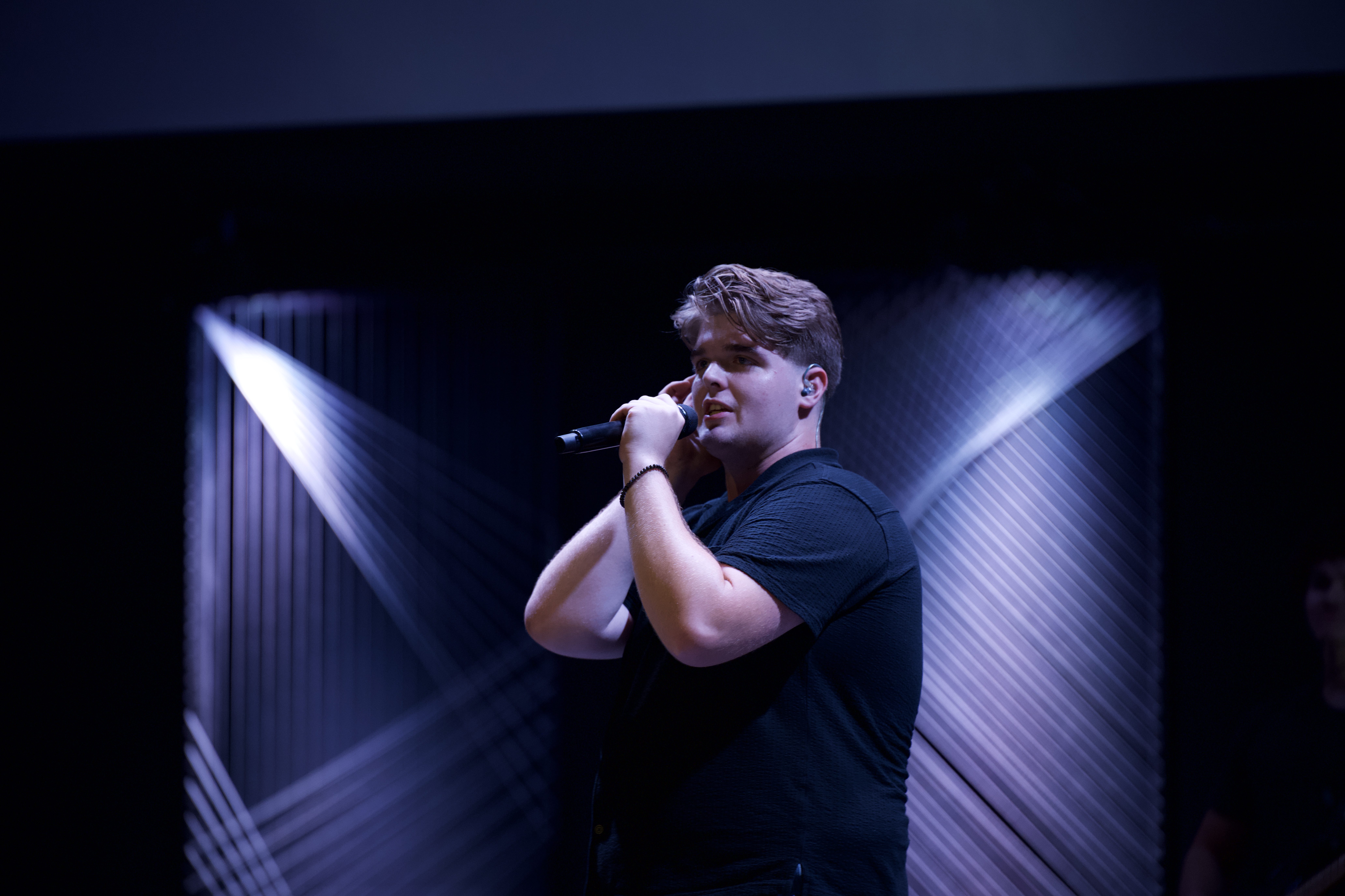 Aaron Snowder 2 A young adult sings on stage at a church