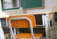 Education essentials Empty classroom with chairs, desks and chalkboard.