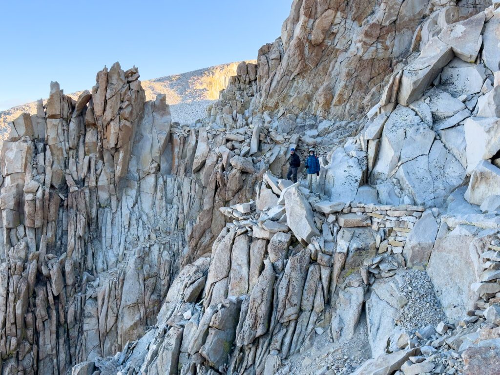 A rocky portion of trail with two men