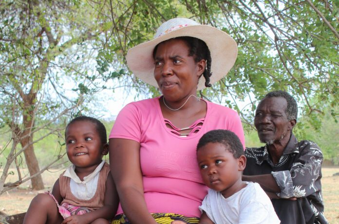 A woman and man sit with two small children.