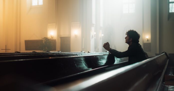 Sitting in pew alone praying