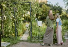 Come with me? Wide shot of unrecognizable young woman and teen girl reading information about rare plants in local botanical garden, copy space