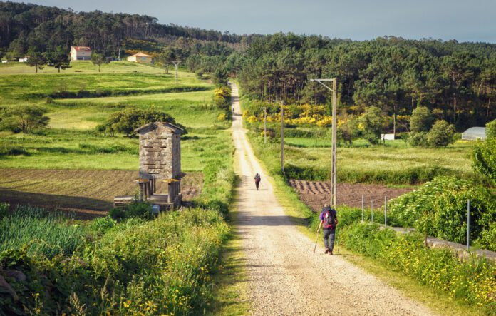 Pilgrims walking along on the Way of St. James, Galicia, Spain Pilgrims walking along on the Way of St. James, Muxia-Fisterra, Galicia, Spain