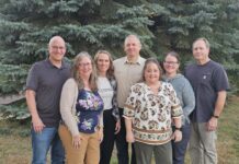 Lending a listening ear Three men and four women stand in front of line of trees.