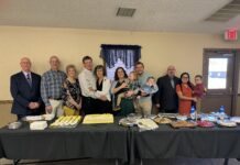Valleyview Bible Church celebrates 100 years of blessings Men and women with families stand in front of dessert tables.