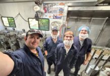 MCC meat canners start season with memories from Malawi Four men in coveralls and hair and beard nets.